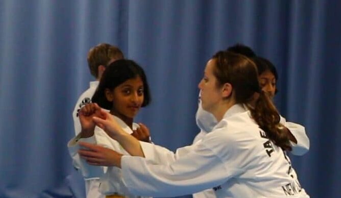 Junior ITF Taekwon-Do students practising colour belt pattern movements during a junior patterns class