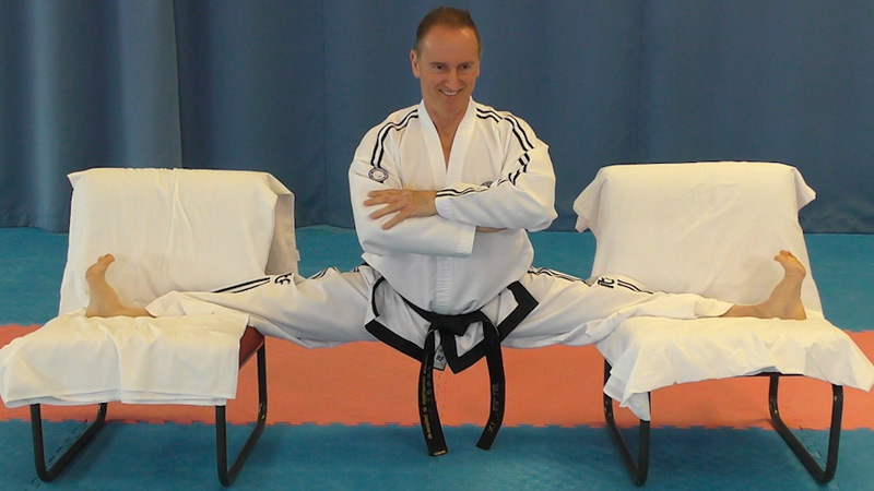 Grand Master Pierre Laquerre demonstrating a seated leg stretch for Taekwon-Do kicking preparation