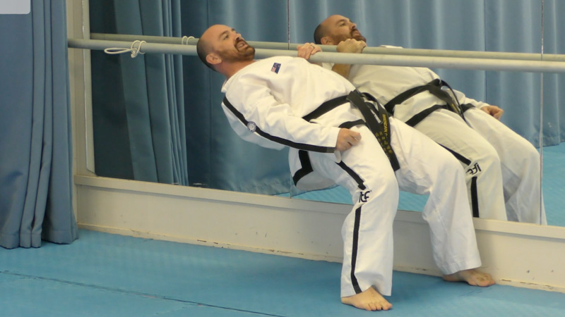 Taekwon-Do practitioners performing a back strength exercise to improve posture and spinal stability